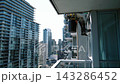 Professional Cleaner On Skyscraper Balcony. Ropeaccess Window Technician Inspecting Tall Glass Building 143286452