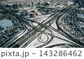 Quiet Urban Highway With Snowcovered Lanes And Looping Ramp Structures In Distance 143286462