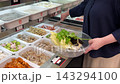 マーラータン（麻辣湯）店で好きな具材を選んでボウルに取り分けている様子 143294100