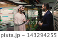 Arabic and Hispanic men colleagues shaking hands, standing in coworking 143294255