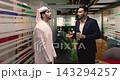 Arabian and Hispanic colleagues lead casual conversation in office hallway 143294257