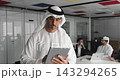 Focused middle-aged Arabic businessman using tablet stands in meeting room 143294265