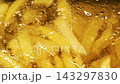 Close-up slow motion fried crispy potato wedges deep frying in oil. French fries 143297830
