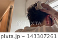 一名男子用毛巾摀著頭髮和頭部。 143307261