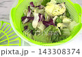 Fresh mixed iceberg and radicchio salad leaves inside plastic salad spinner on kitchen table for washing drying and preserving greenery concept. 143308374