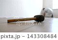 Close-up of rubber mallet lying on laminate floor while worker installs flooring panels in the background. Home renovation and floor installation concept. 143308484