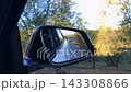 Close up of car side mirror reflecting outdoor road landscape during drive Close up of car side mirror reflecting outdoor road landscape during drive 143308866