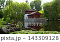 Static View of Traditional Red Pavilion Reflected in Tranquil Garden Pond 143309128