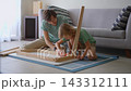 Father and ten-year-old son assembling wooden table on floor. Family teamwork. 143312111
