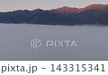 A sea of clouds and the morning glow over the Hakuba mountain range in Hakuba Village, Nagano Prefecture (aerial photography by drone). 143315341