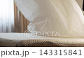 A man in a bedroom straightens a white sheet on a bed with his hands and smooths it over the surface. Slow motion. Close up shot 143315841