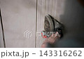 Close-up of a worker cutting wall grooves with an angle grinder for concealed electrical wiring installation. 143316262