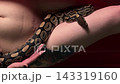 Close view of a snake at a tattooed model's hip and her face 143319160