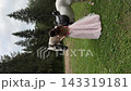 Model in a pink gown holding reins as a white horse turns 143319181