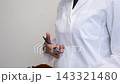 A person in a white coat fills out paperwork while talking about the body. 143321480