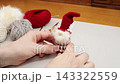 A picture of someone enjoying looking at their finished creation: a handmade Tomte, a Nordic fairy, made from yarn. 143322559