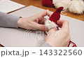 Making a Tomte, a Nordic fairy, out of yarn: The process of assembling the parts. 143322560