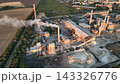 Raw material stockpiles and inclined belt conveyors at a cement plant in drone aerial view. Cement manufacturing, bulk material handling and mineral stockyard logistics 143326776