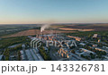 Cement plant with silos, kiln lines and rail sidings in a drone aerial view. Construction materials, bulk storage and industrial logistics infrastructure 143326781