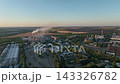 Cement plant with storage silos, production buildings and railway sidings in a drone aerial view. Construction materials logistics, bulk storage and cement distribution infrastructure 143326782