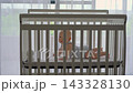 Five-month-old baby boy lying in crib with baby monitor camera in front of him. Infant monitoring 143328130