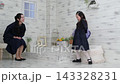 一位6歲的日本女孩背著書包走在路上，她30多歲的母親在一旁看著。 143328231