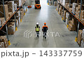 Autonomous Platforms Moving Cargo Boxes Through Warehouse | Aerial Drone View of Smart Logistics Automation. Aerial View of Warehouse Workers and Loader Moving Cargo Boxes onto Autonomous Platform 143337759