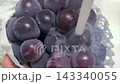 The scene of washing fresh Kyoho grapes, glistening with water droplets, under running water. 143340055