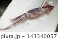 Freshly caught squid being washed under running water before cooking. 143340057