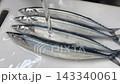 Preparing the saury by washing it under running water before cooking. 143340061
