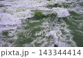 A Close-up View of Turbulent River Rapids with White Foam and Greenish Water. 143344414