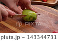 Knife Cutting Juicy Kiwi On Wooden Board For Milk Jelly Cake 143344731