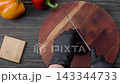Slicing beef ham on wooden board with ingredients top view 143344733