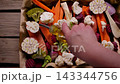 Woman Pouring Oil on Mixed Vegetables for Sunday Roast Top View 143344756