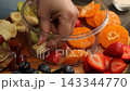 Hand Placing Juicy Fruit Pieces Into Clear Mold 143344770