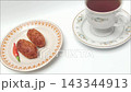 Fried croquettes on plate next to black coffee cup on white table 143344913