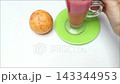 Hand placing fresh juice glass on table near organic guava 143344953