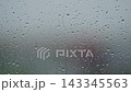 Rain drop hitting window glass and sliding down 143345563