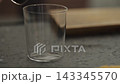 Pour milk into glass with shot of espresso 143345570