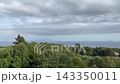A cloudy coastal landscape with islands visible in the distance. 143350011