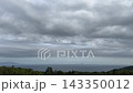 A cloudy coastal landscape with islands visible in the distance. 143350012
