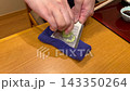 A hand that grates fresh wasabi with a metal grater. 143350264