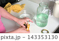 A woman carefully transfers medicinal leeches from a bag of peat into a jar of water. This process is part of hirudotherapy for health and wellness treatments 143353130