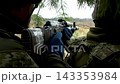 Soldiers in a dugout aiming from cover at a target during combat.  143353984