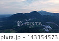 Drone shot of Tangkak farmland and forested mountains at dusk. 143354573