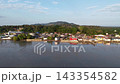 Sunlit aerial view of Segenting shoreline and stilt houses in Batu Pahat during calm evening. 143354582
