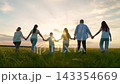 Parents, dad mom children picnic, green lawn. Happy group people, adults children, enjoy walk on green grass. Happy family, children, papa mama son daughter stroll through summer field, holding hands 143354669