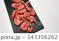 Close-up view of pink frozen shrimps on a white background on a black board. Seafood concept, seafood cooking. High quality 4k footage 143356262