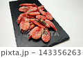 Side view close-up of pink frozen shrimps on a white background on a blackboard, the camera zooms in smoothly. Seafood concept, seafood cooking. High quality 4k footage 143356263
