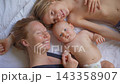 Happy mother lying on bed with her two sons. Loving family moment. 143358907